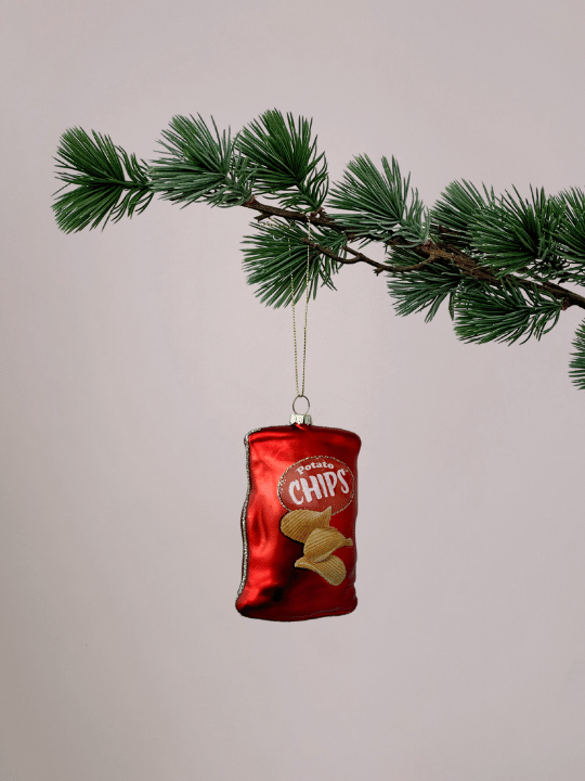 Gekke Vondels kerstbal in de vorm van een rode chipszak met afgebeelde chipjes hangend in een kerstboom.