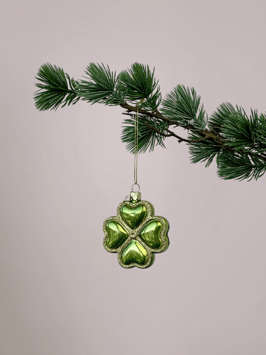 Vondels geluksornament groen klavertje vier met gouden glitterranden hangend in een kerstboom.