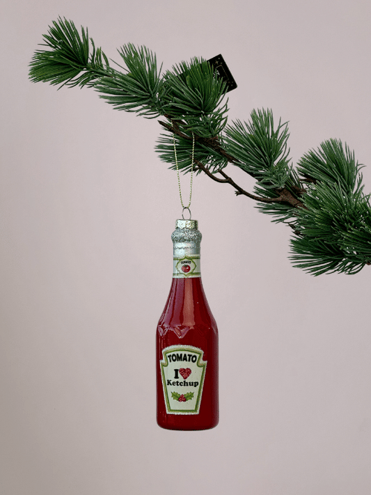 Vondels rode ketchupfles kerstbal met lange hals en zilveren glinsterende dop hangend in een kerstboom.