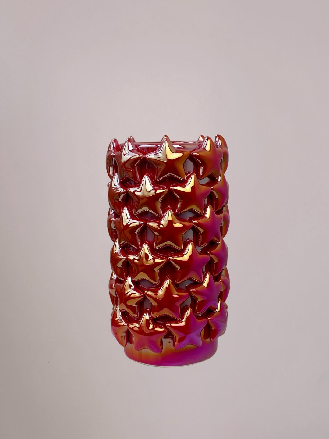 Kleine rode vaas van opzij, holografische glans varieert van roze, goud tot zilver, sterren zichtbaar op het oppervlak