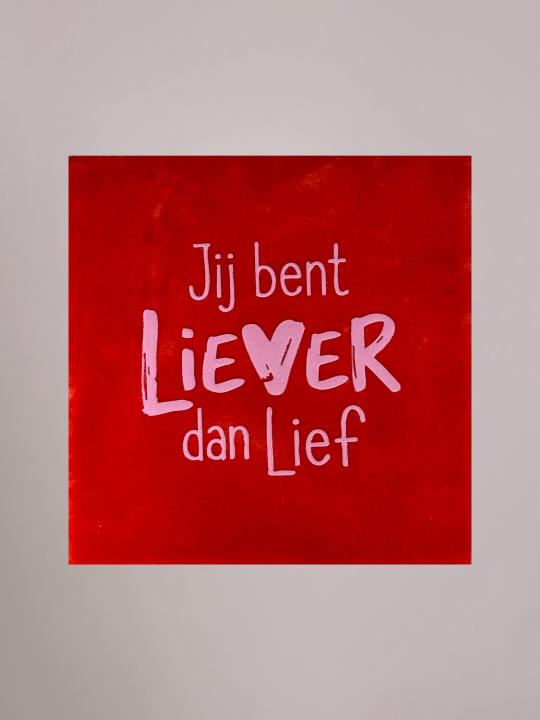 Rood keramieken tegeltje met lichtroze tekst “Jij bent liever dan lief” en hartvormige v