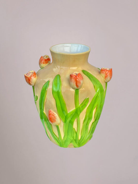 Decoratieve tulpenvaas van keramiek met oranje tulpen en groene stengels als woonaccessoire