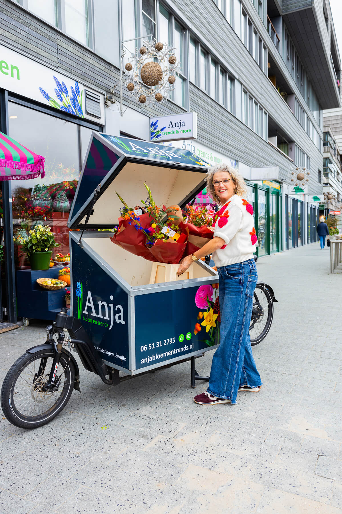 Anja van Anja Bloementrends lacht terwijl ze bloemen in haar bezorgfiets zet in Zwolle