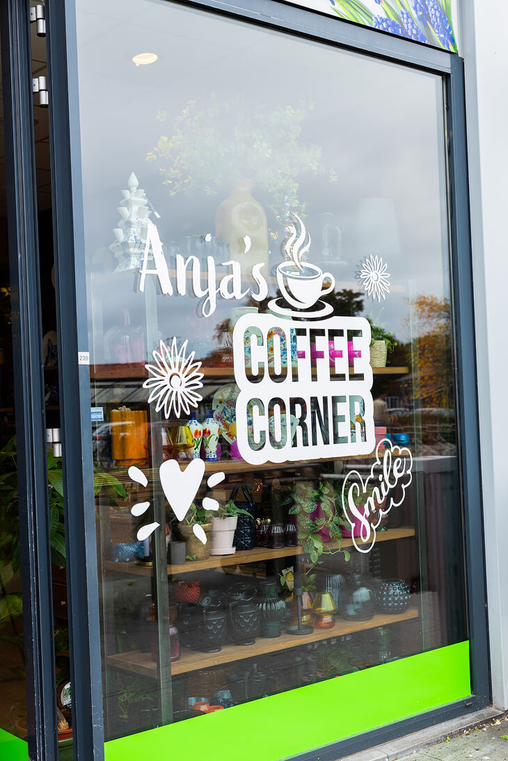 Raam van Anja Bloementrends koffiecorner in bloemenwinkel met sfeervolle bestickering
