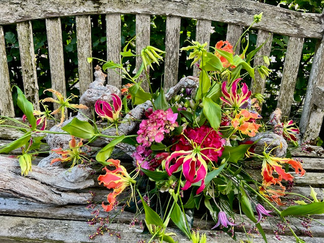 Roze wildpluk rouwboeket met trosroos en delicate veldbloemen