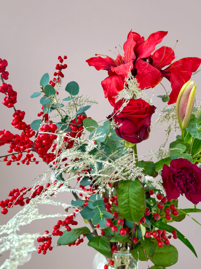 Close-up van rode kerstbloemen met wintergroene textuur bloemen bezorgen Zwolle.