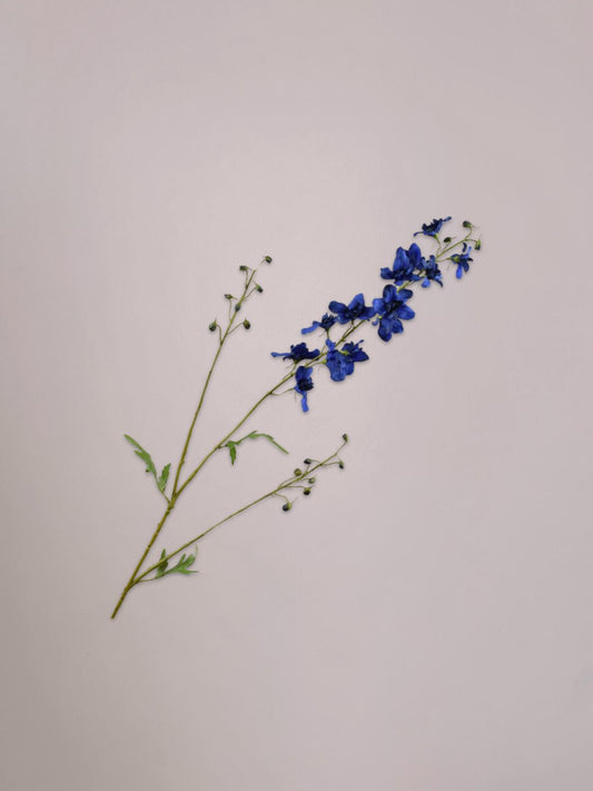 Blauwe delphinium kunsttak van Silk-ka met sierlijke bloemtrossen en groene steel in een vaas