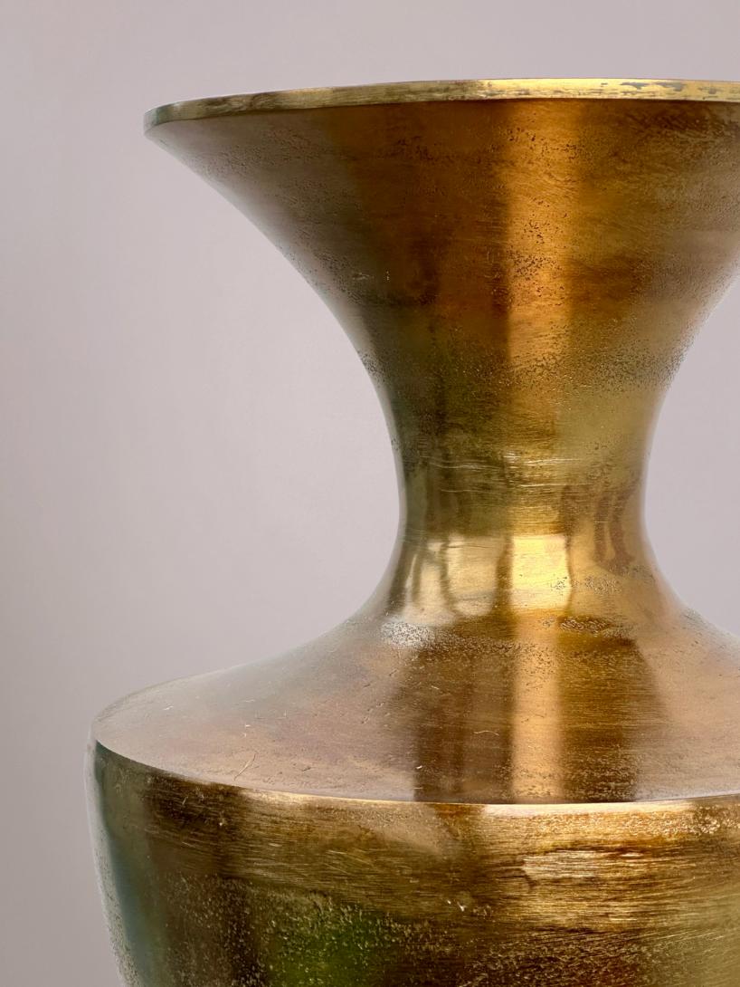 Close-up van gestructureerde glanzende bronzen afwerking op gouden vaas