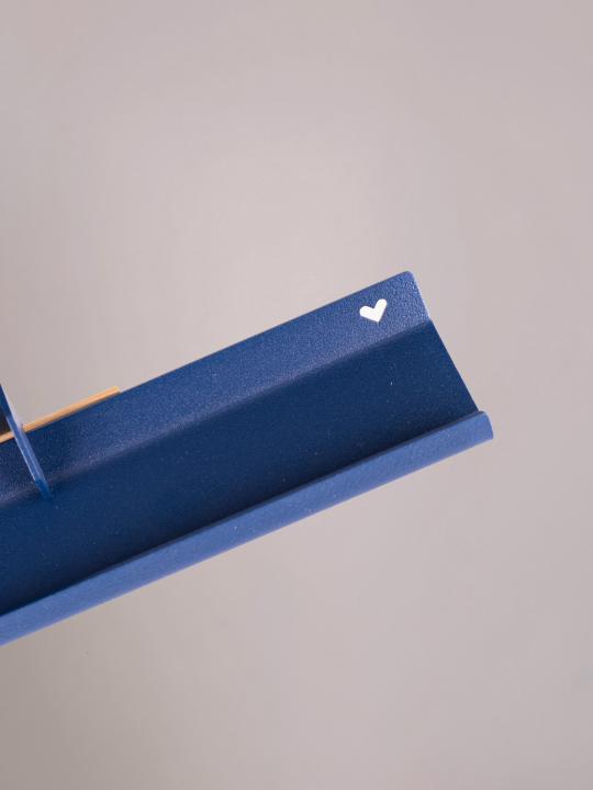 Detail van het uitgesneden hartje in de donkerblauwe wandplank medium van Studio Mippe, elegant en verfijnd.