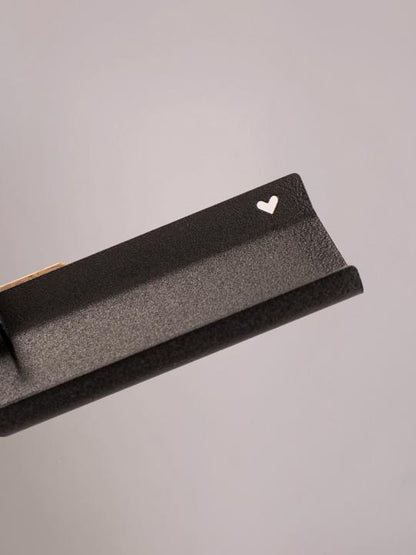 Detailfoto van het uitgesneden hartje in de zwarte wandplank medium van Studio Mippe, modern en strak.