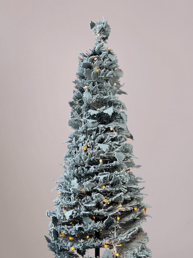 Detailfoto van takken en verlichting van de pop up kerstboom in daglicht voor een natuurlijke en volle uitstraling.