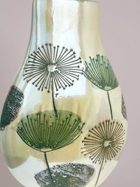 detail van smalle vaas vensterbank met paardenbloemen en glazuurlaag