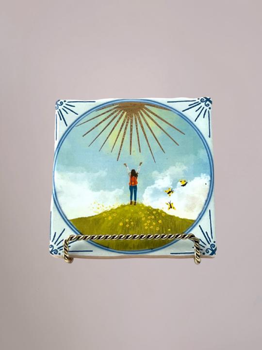 StoryTiles Face the Sunshine tegeltje van 10x10 cm met een warme, zonnige illustratie. Handgemaakt in Nederland en een betekenisvol cadeau waarvan een deel van de opbrengst naar Fight cancer gaat.