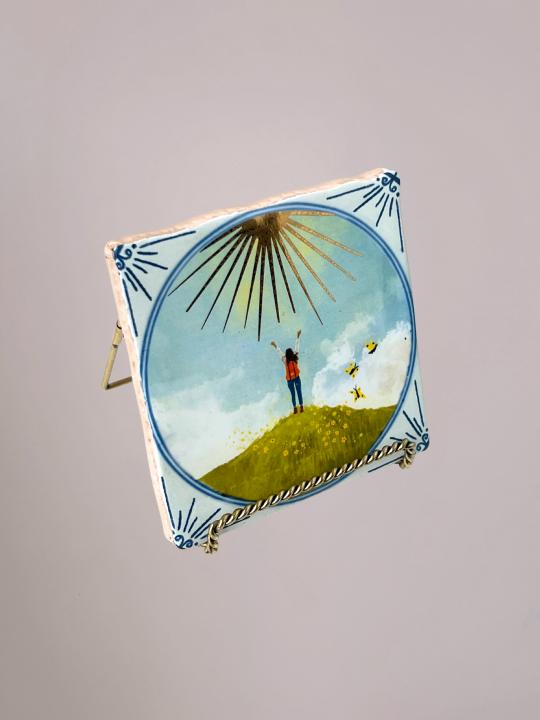 StoryTiles Face the Sunshine tegeltje van 10x10 cm met een warme, zonnige illustratie. Handgemaakt in Nederland en een betekenisvol cadeau waarvan een deel van de opbrengst naar Fight cancer gaat.