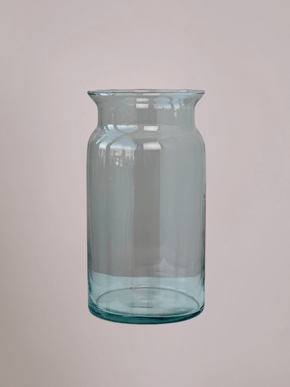 Cilindervormige glazen vaas met roze achtergrond