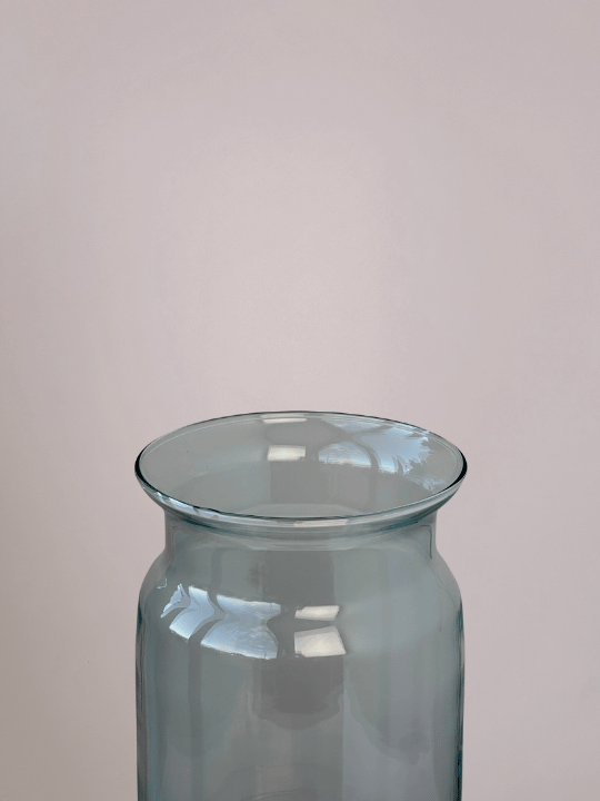 Close-up van boven van cilindervormige doorzichtige vaas met roze achtergrond