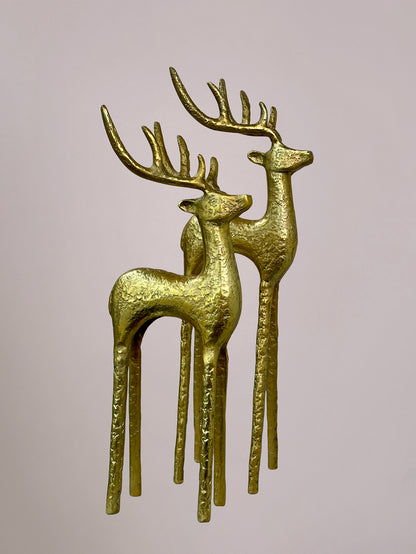 Twee gouden rendieren als kerstdecoratie op lichtroze achtergrond, één klein en één groot, los of als set verkrijgbaar.
