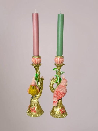 Gouden kandelaar met vogel in de vorm of detail van een lichtroze kaketoe en lichtgroene accenten, volledig in beeld weergegeven.