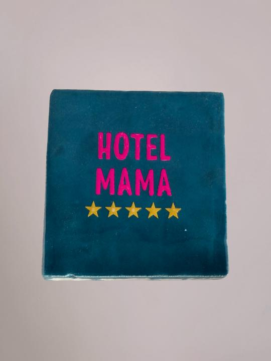 Blauw keramiek tegeltje met de tekst “Hotel Mama” van Yett Agenturen