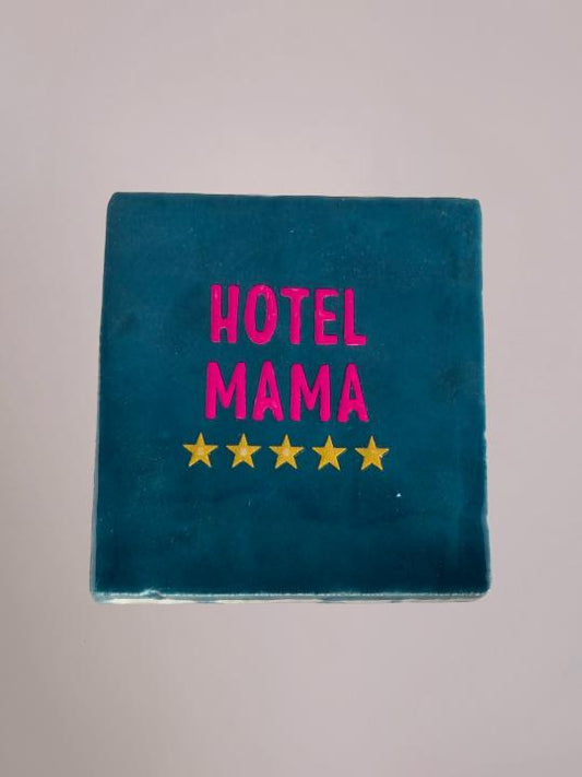 Blauw keramiek tegeltje met de tekst “Hotel Mama” van Yett Agenturen