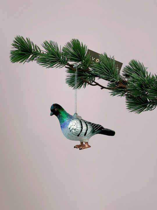Kerstornament Vondels stadsduif met grijs, wit, zwart, groen en blauw in de nek en oranje poten hangend in een kerstboom.