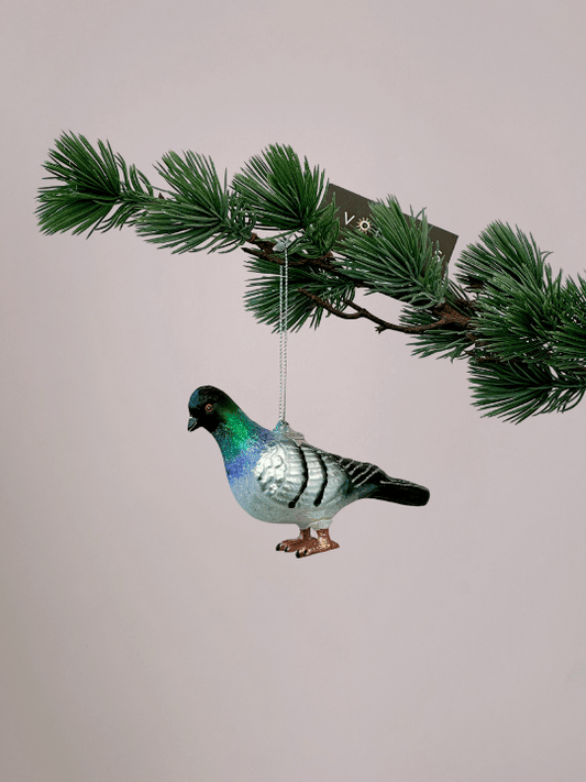 Kerstornament Vondels stadsduif met grijs, wit, zwart, groen en blauw in de nek en oranje poten hangend in een kerstboom.
