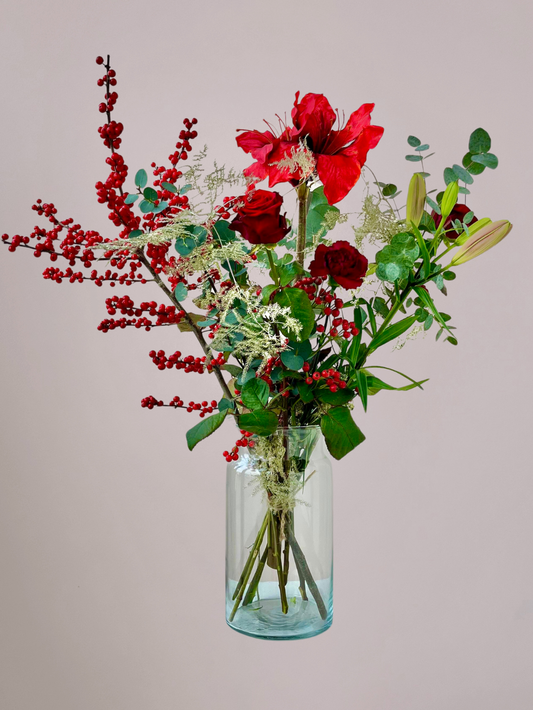 Rood kerstboeket met wintergroen en feestelijke accenten en laat bloemen bezorgen Zwolle.