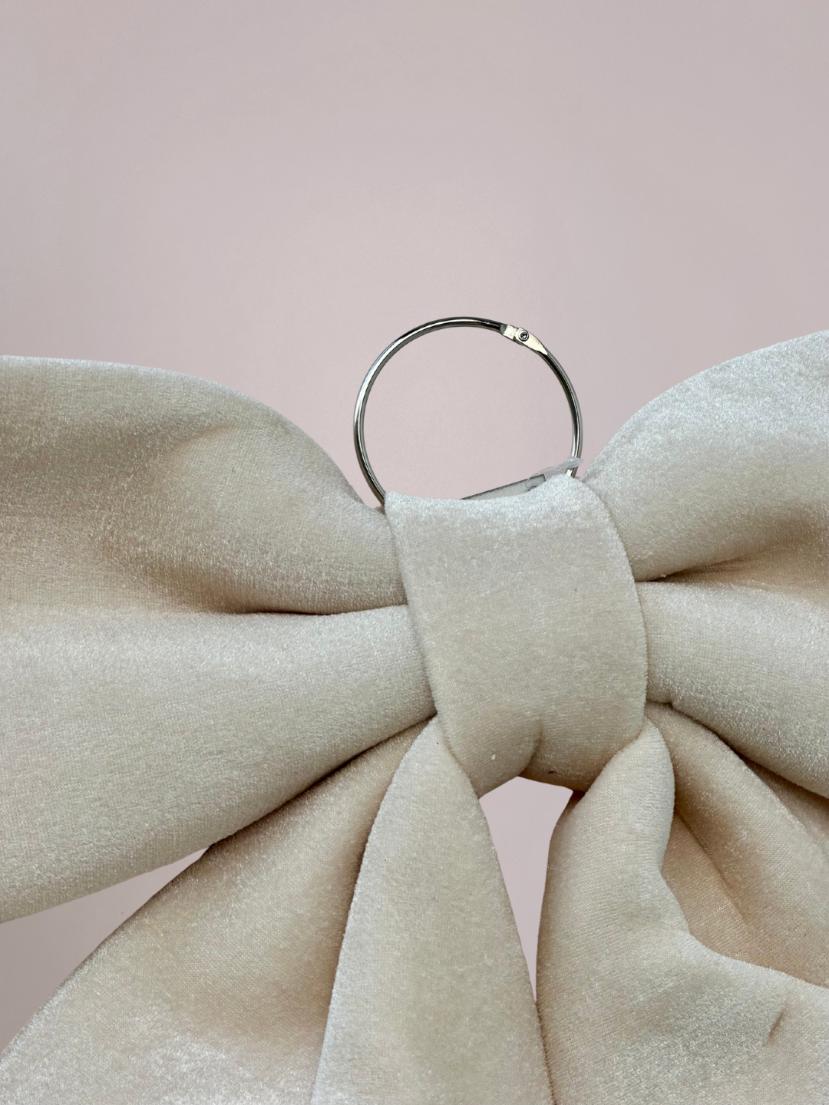 Detail van creme kerststrik met fluffy velvet-look en ophanghaak, perfect om aan deur of muur te hangen