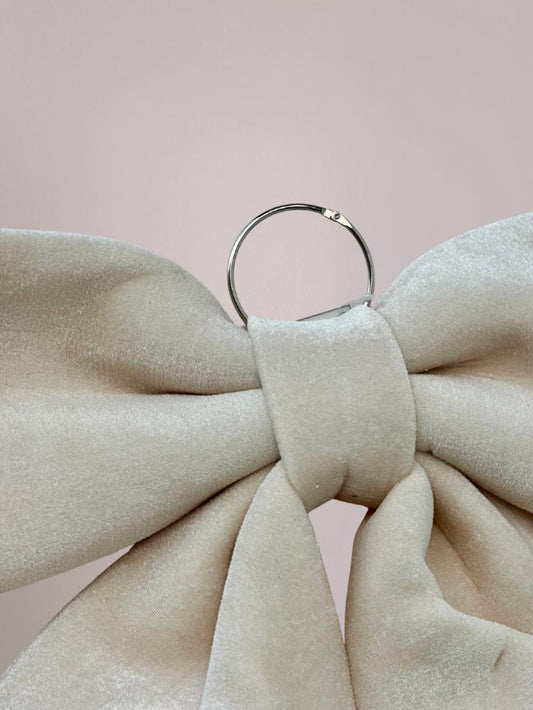 Detail van creme kerststrik met fluffy velvet-look en ophanghaak, perfect om aan deur of muur te hangen