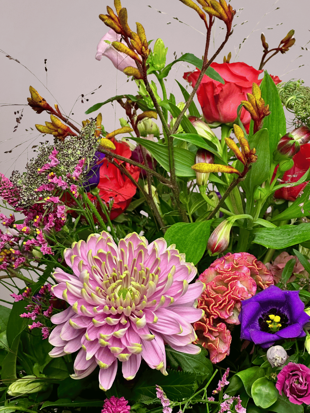 Modern rouwboeket met krachtige kleuren en speelse bloemcombinaties, vakkundig gebonden in Zwolle