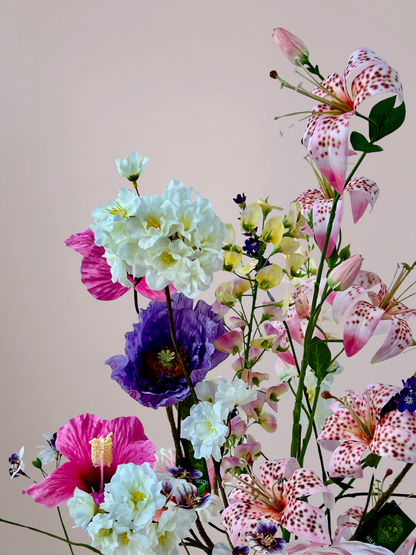Kleurrijk Moederdag kunstboeket met gemengde bloemen in roze, wit, paars en gele tinten met een volle luxe uitstraling