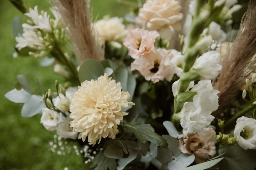 Rond bruidboeket met witte bloemen en trosrozen, elegant en tijdloos