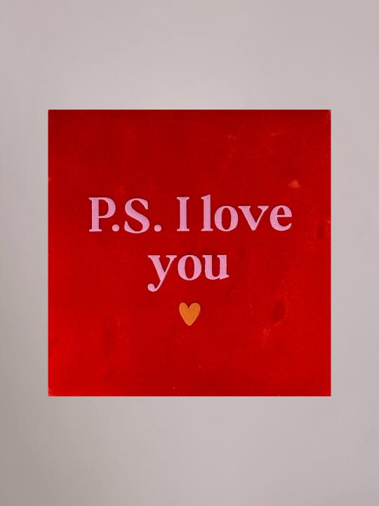 Rood keramieken tegeltje met lichtroze tekst “P.S. I love you” en klein oranje hartje. Handgemaakt, lief en romantisch cadeautje van Yett Agenturen.