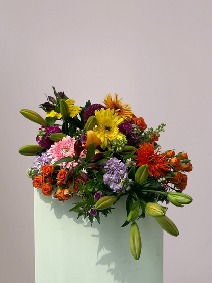 Kleurrijk rouwboeket met gemengde bloemen in roze, geel, paars en oranje tinten