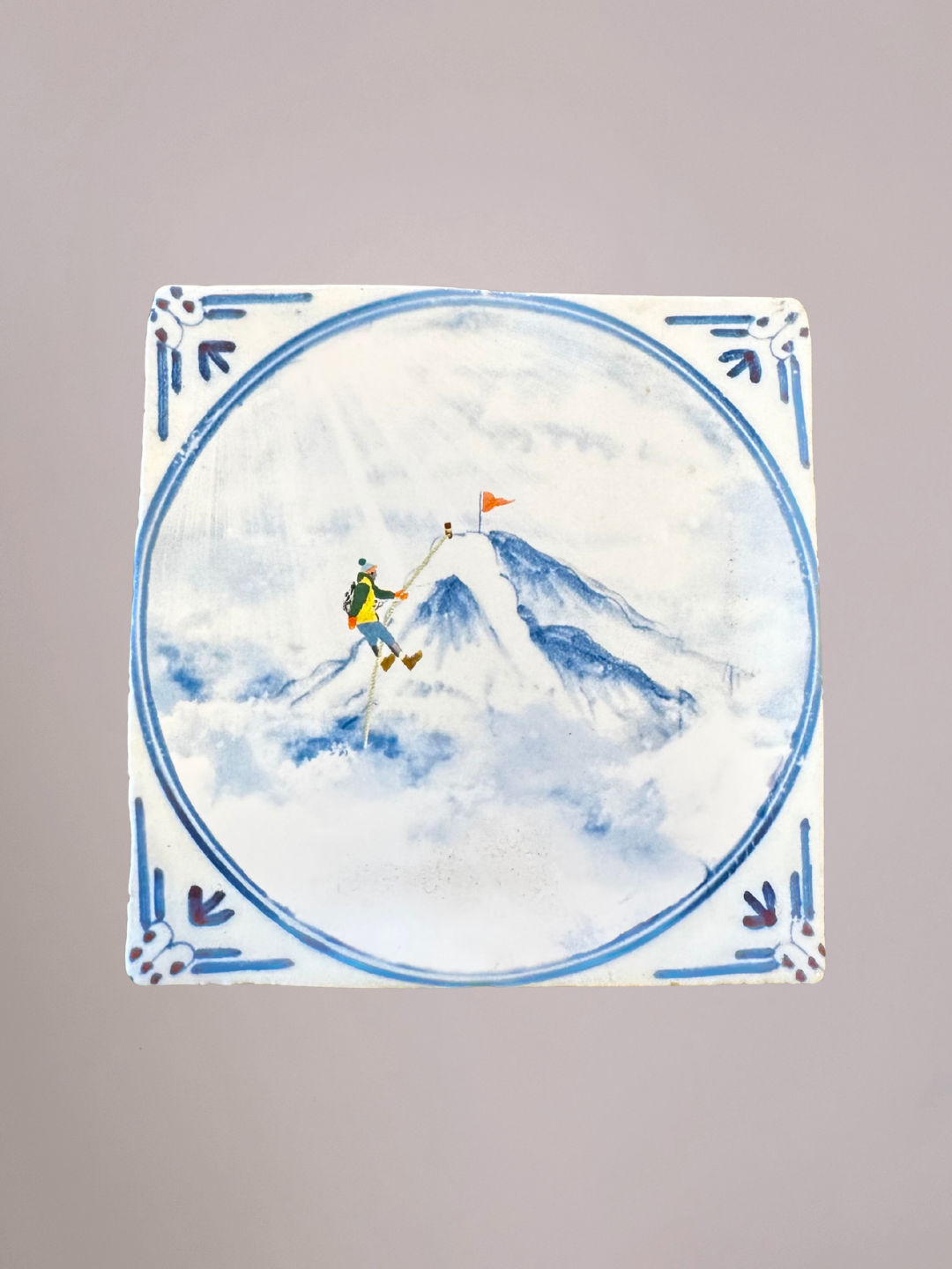 StoryTiles Reaching The Top Delfts Blauw tegeltje met besneeuwde berg en klimmer