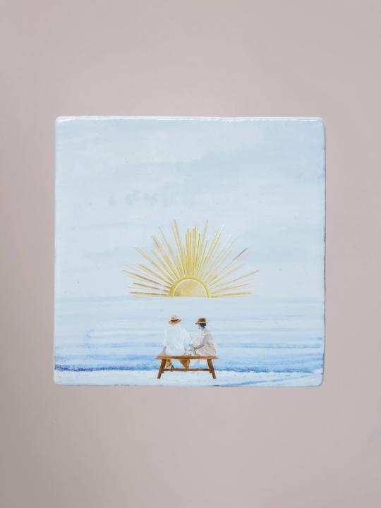 Handgemaakte StoryTiles tegel van 10x10 cm met glinsterende gouden zon en illustratie van zonsondergang.