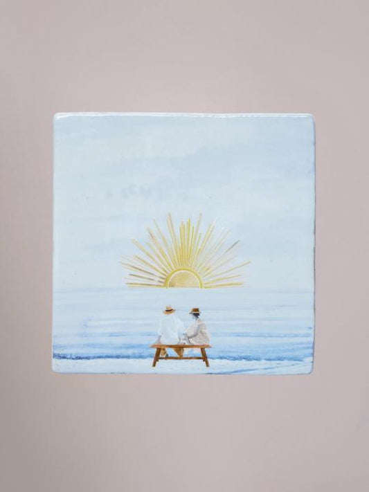 Handgemaakte StoryTiles tegel van 10x10 cm met glinsterende gouden zon en illustratie van zonsondergang.
