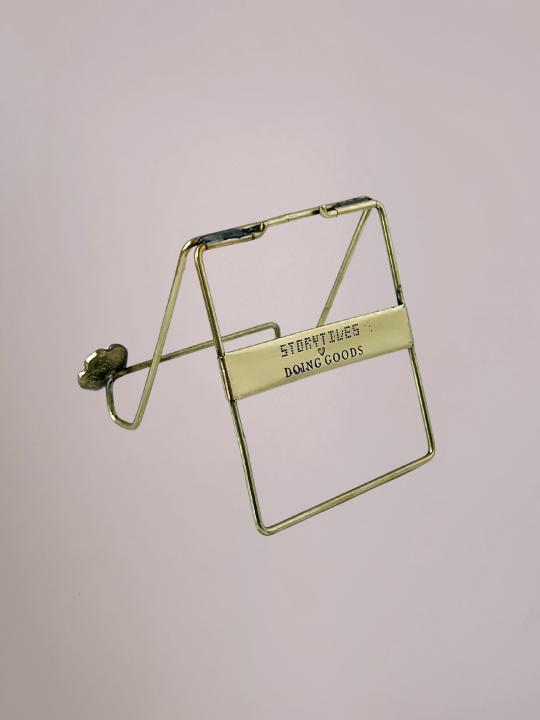 Gouden messing tegelhouder van StoryTiles met bloemdetail en zacht roze kleurverloop in het midden, geschikt voor decoratieve tegels.