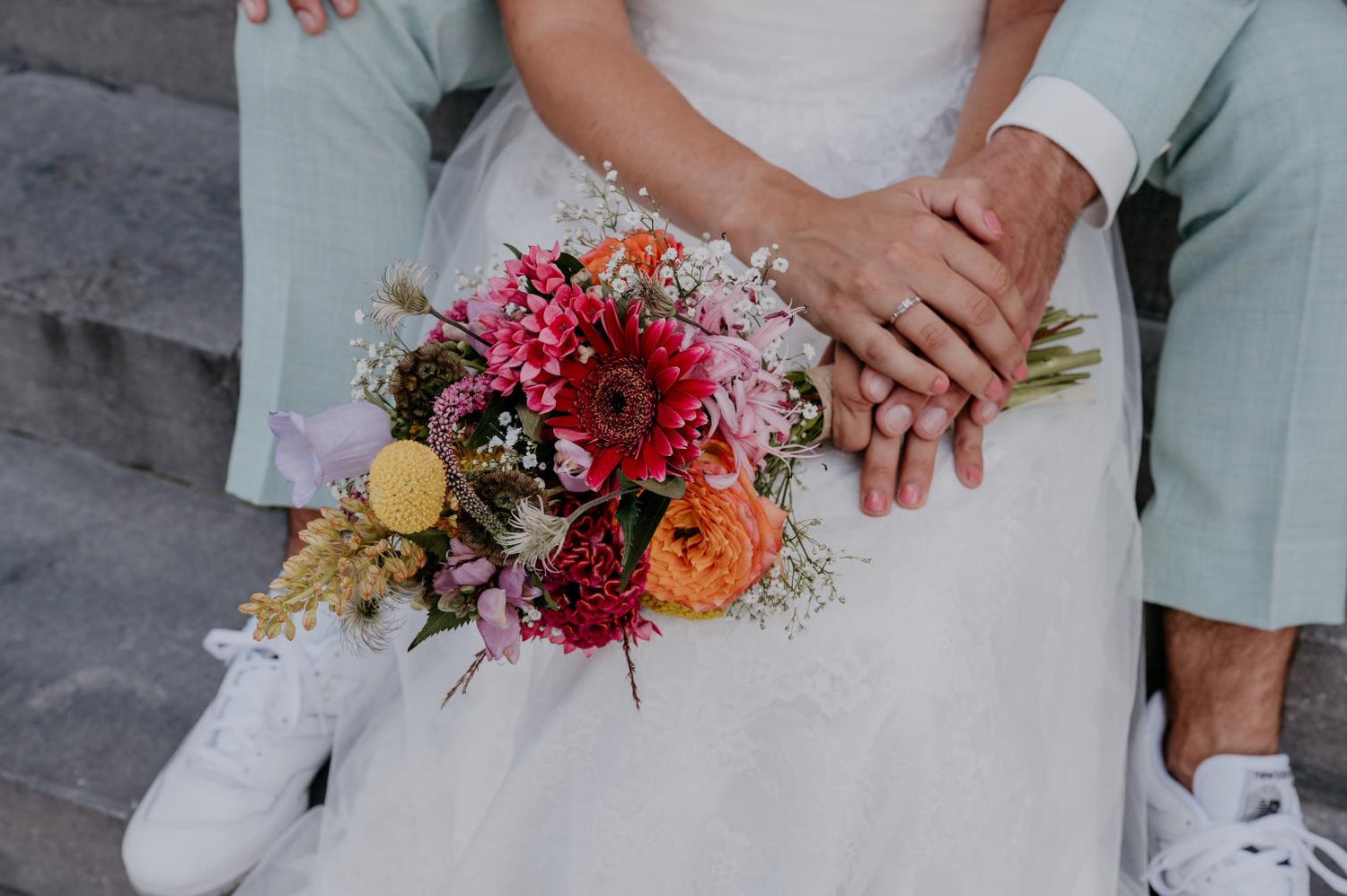 Gekleurd Bruidsboeket in handen van bruid en bruidegom van Anja Bloementrends in Zwolle