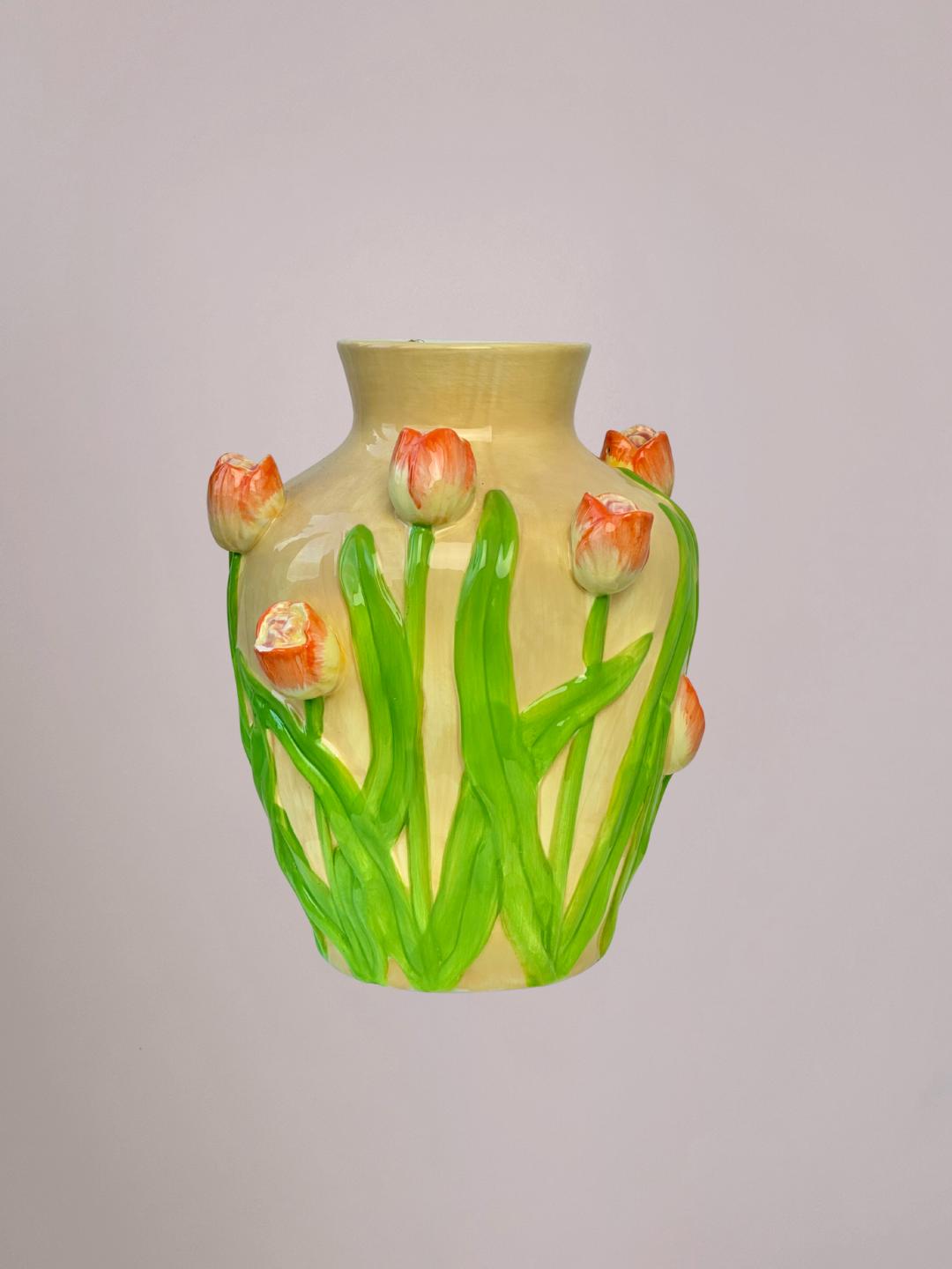 Keramieken vaas met oranje tulpen en groen blad in reliëf, beige en licht oranje tinten