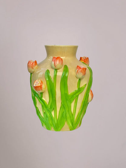 Keramieken vaas met oranje tulpen en groen blad in reliëf, beige en licht oranje tinten