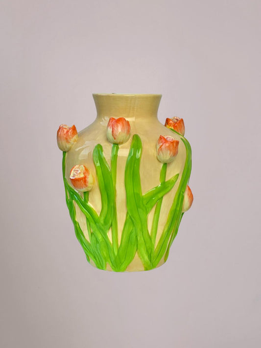 Keramieken vaas met oranje tulpen en groen blad in reliëf, beige en licht oranje tinten