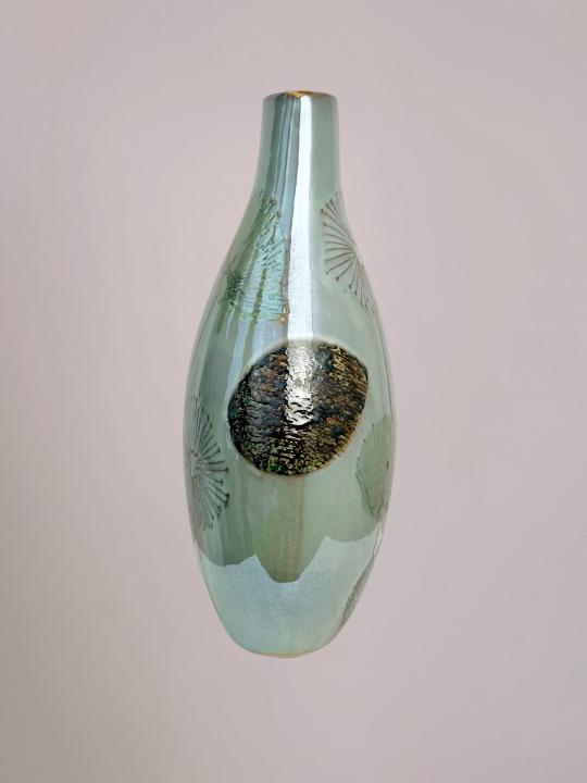 zijkant van lichtgroene vaas vensterbank met platte vorm