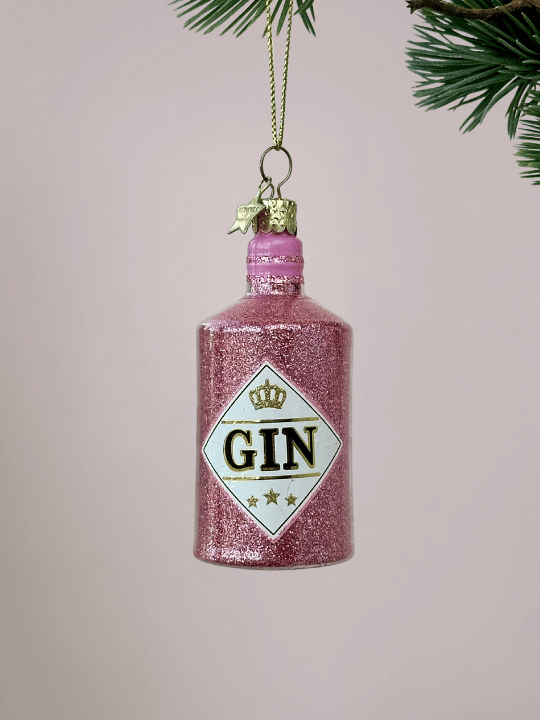 Roze Ginfles Kerstbal Vondels met glitters oplichtroze achtergrond.