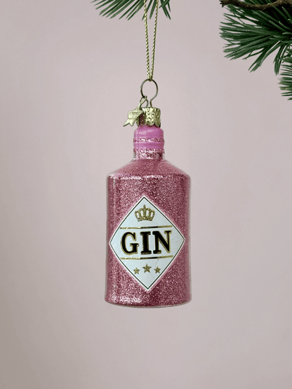 Roze Ginfles Kerstbal Vondels met glitters oplichtroze achtergrond.