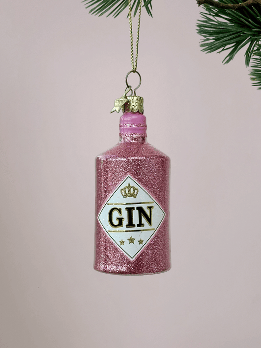 Roze Ginfles Kerstbal Vondels met glitters oplichtroze achtergrond.