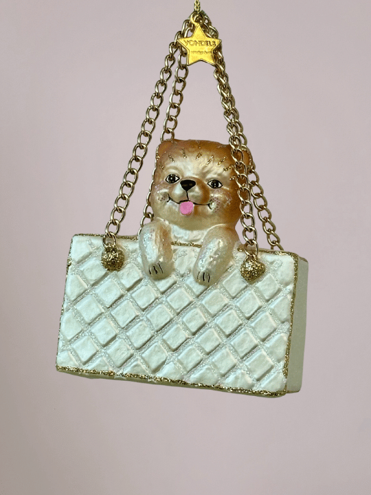 Close-up van witte handtas kerstbal met hondje, ruitkusseneffect, glitters en gouden metalen koordjes, bijzondere kerstbal en Vondels kerstornament