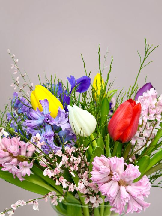 Kleurrijk lenteboeket met tulpen, geurige hyacinten en volle ranonkels