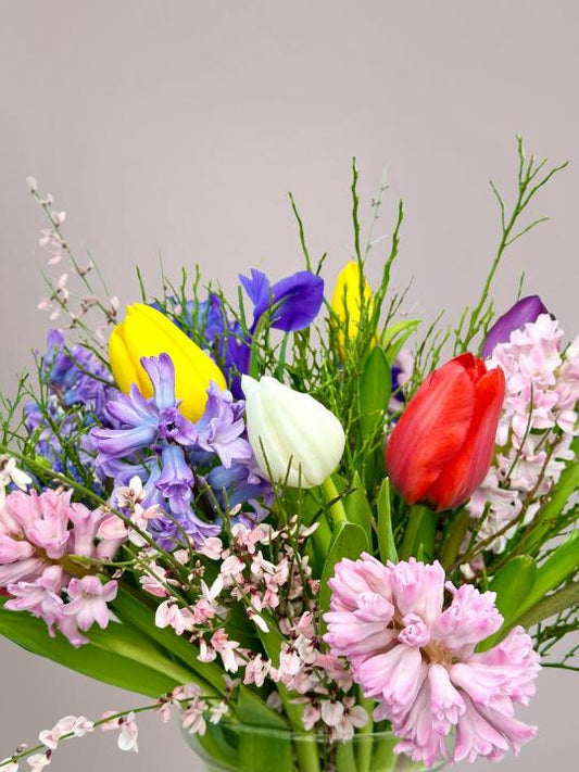Kleurrijk lenteboeket met tulpen, geurige hyacinten en volle ranonkels