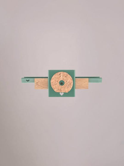 Achterzijde van het groene wandplankje met ophangpunten.